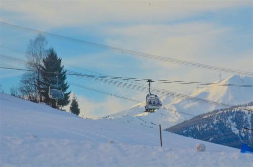 a ski lift going up a snow covered mountain at Ski-in Ski-out Chalet Maiskogel 13A - by Alpen Apartments in Kaprun