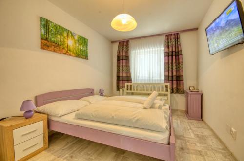 - une chambre avec un lit et une télévision murale dans l'établissement Apartment Valentina - by Alpen Apartments, à Zell am See