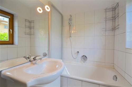 a white bathroom with a sink and a tub at Apartment Valentina - by Alpen Apartments in Zell am See