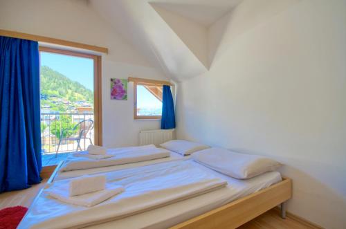 sypialnia z dwoma łóżkami i dużym oknem w obiekcie Apartment Central - by Alpen Apartments w mieście Zell am See