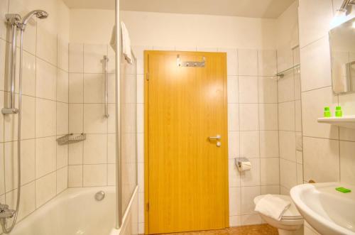 ツェル・アム・ゼーにあるApartment Central - by Alpen Apartmentsのバスルーム(シャワー付)、木製のドアが備わります。