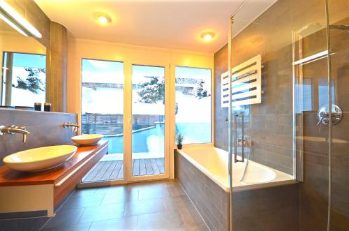 ツェル・アム・ゼーにあるAPT Super Zell -by Alpen Apartmentsのバスルーム(シンク2台、バスタブ、シャワー付)