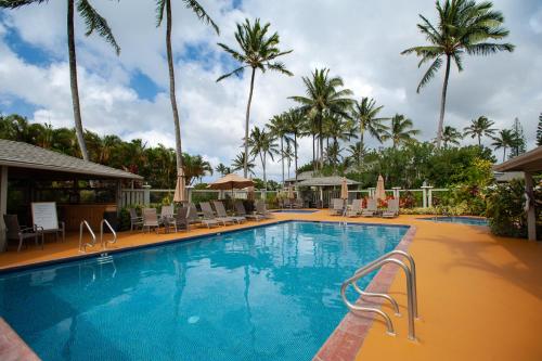 une grande piscine avec des chaises et des palmiers dans l'établissement Alii Kai II 11B, à Princeville