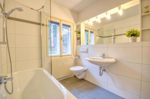 a bathroom with a tub and a sink and a toilet at Mozart Top 3 - by Alpen Apartments in Zell am See