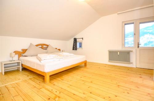 a bedroom with a bed and a wooden floor at Mozart Top 3 - by Alpen Apartments in Zell am See