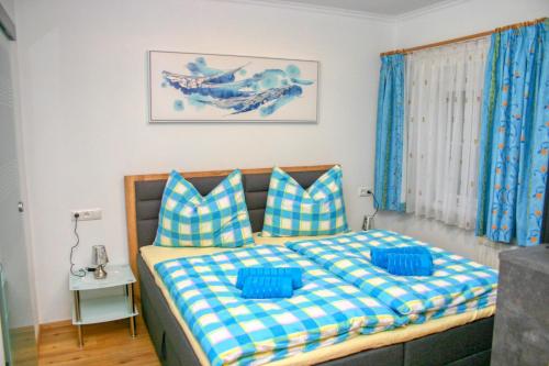 a bedroom with a bed with blue and white pillows at Apartment Birke 3 - by Alpen Apartments in Bad Gastein