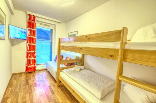 2 Etagenbetten in einem Zimmer mit Fenster in der Unterkunft Penthouse Ari - by Alpen Apartments in Zell am See