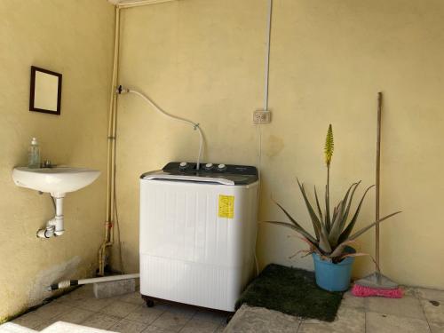a bathroom with a sink and a small refrigerator at Hostal Las Quince Letras in Tehuacán