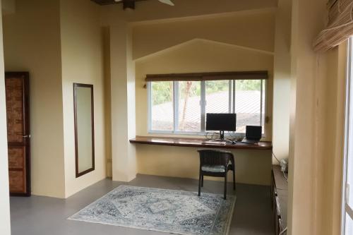 a room with a desk with a computer and a window at Siargao Million Dollar View in Burgos