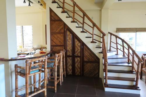 a staircase in a kitchen with a table and chairs at Siargao Million Dollar View in Burgos