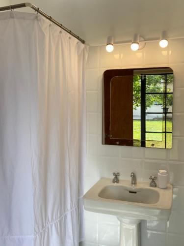 a white bathroom with a sink and a mirror at Doña Hilda in Mercedes