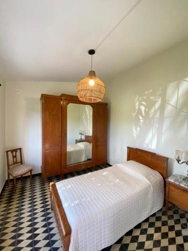 1 dormitorio con cama, espejo y silla en Doña Hilda en Mercedes