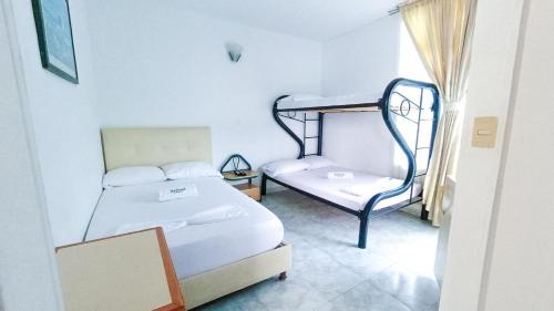 a room with two beds and a bunk bed at Hotel Miami en Melgar in Melgar