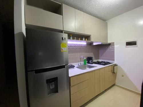 una cucina con frigorifero in acciaio inossidabile e lavandino di Apartamento completo con aire en Valledupar a Valledupar
