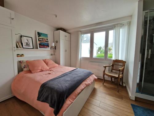 une chambre avec un lit, une fenêtre et une chaise dans l'établissement Apartment in Bénodet near Sandy Beaches, à Bénodet