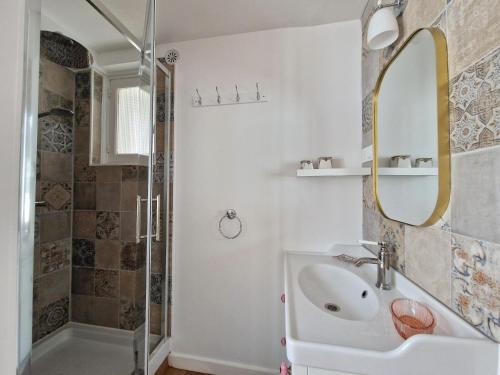 une salle de bain avec un lavabo, un miroir et une douche dans l'établissement Apartment in Bénodet near Sandy Beaches, à Bénodet
