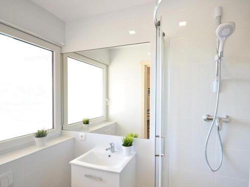 a bathroom with a shower and a sink and a mirror at Holiday cottages, pool, whirlpool, D bki in Dąbki