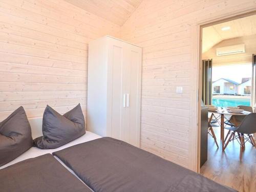 a bedroom with a bed with pillows and a table at Comfortable holiday cottages, pool whirlpool D bki in Dąbki