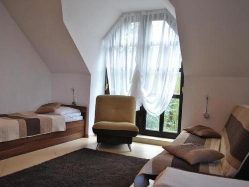 a bedroom with two beds and a chair and a window at Villa in Brenna near Ski Lifts & Pool in Brenna
