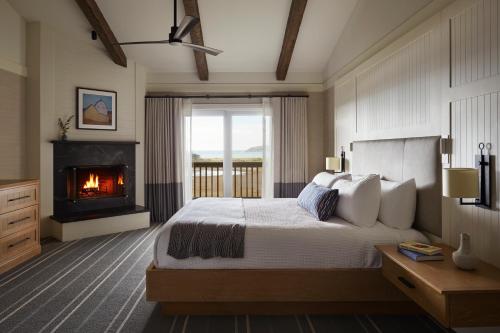 a bedroom with a large bed with a fireplace at The Lodge at Bodega Bay in Bodega Bay