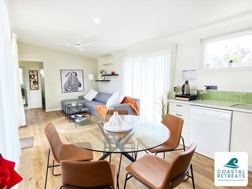 a kitchen and a living room with a glass table at Woodland Retreat - Phillip Island in Cowes