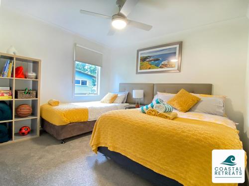 1 dormitorio con 2 camas con sábanas amarillas en Woodland Retreat - Phillip Island - Ramada Resort, en Cowes