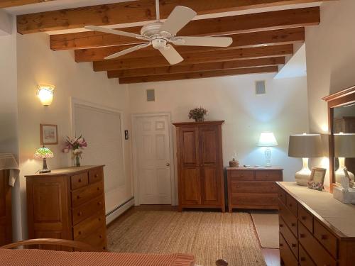 a living room with a ceiling fan and a dresser at High Hill Inn in East Montpelier