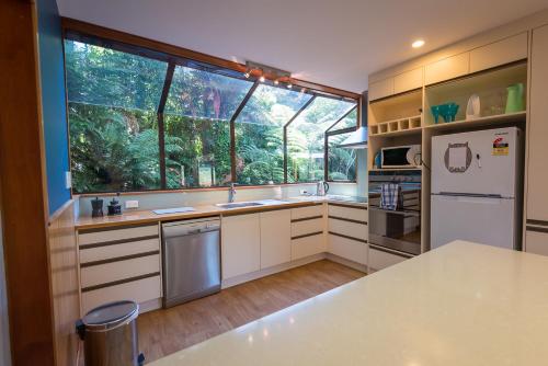 a kitchen with white cabinets and a large window at Ridge Retreat in Rotorua