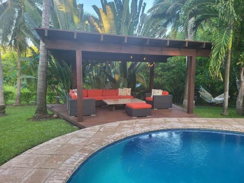 a gazebo with a couch and a table next to a pool at Casa Don Willo in Escuintla