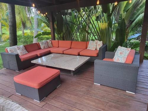 a patio with a couch and a table on a deck at Casa Don Willo in Escuintla