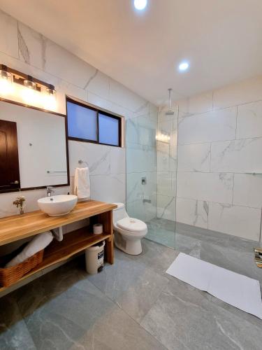 a bathroom with a toilet and a sink and a shower at Pinilla Highlands Incredible mountain views in Tamarindo