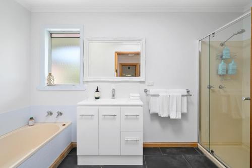 a white bathroom with a tub and a sink at LuCo House Stanley in Stanley