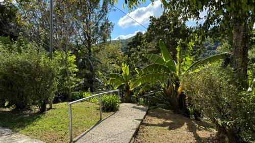 a walkway in a garden with trees and bushes at Koi's House - Quebradillas de Dota in Santa María