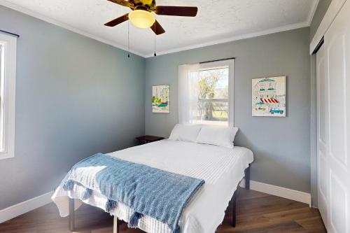 1 dormitorio con 1 cama y ventilador de techo en Gulf Breeze Bliss, en Parrish