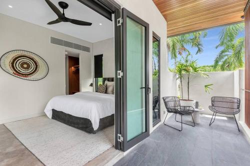 een slaapkamer met een bed en een glazen schuifdeur bij 8 Beachfront Mirage in Port Douglas