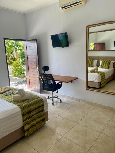 een slaapkamer met een bureau, een stoel en een spiegel bij Canggu - Pererenan Guesthouse " aBaliHouse " in Canggu