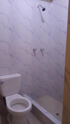 ein weißes Bad mit einem WC und einer Dusche in der Unterkunft habitación con cocina in Cajamarca