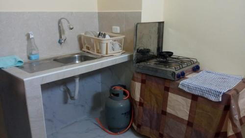 eine Küche mit einer Spüle und einer Arbeitsplatte in der Unterkunft habitación con cocina in Cajamarca