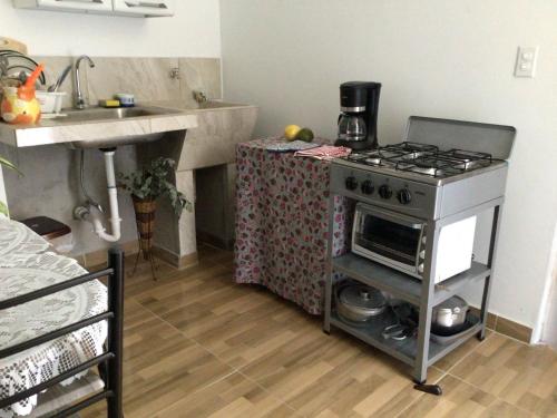 una cucina con piano cottura e bancone con lavandino di Urbano y comodo a David