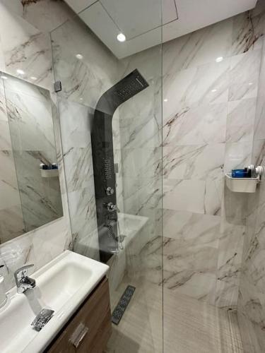 a white bathroom with a sink and a shower at Racine Studio bd Anfa in Casablanca