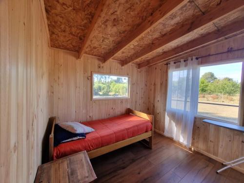 Posto letto in camera in legno con finestra. di Hospedaje Punto Austral a Los Muermos