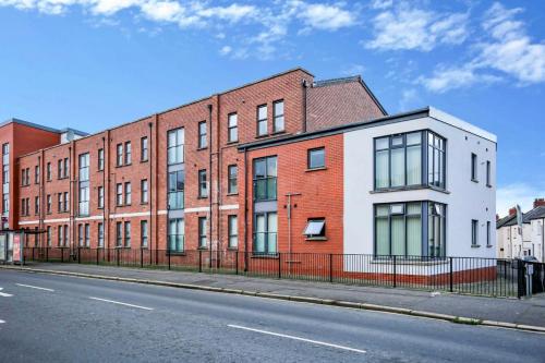 un edificio de ladrillo al lado de una calle en Neat City Apartment - Secure Parking - WiFi - Sleeps 4 - No Parties, en Belfast