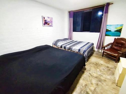 - une chambre avec deux lits, une chaise et une fenêtre dans l'établissement Dpto. 1er piso 4 hab.Piscina Terraza, à Punta Hermosa