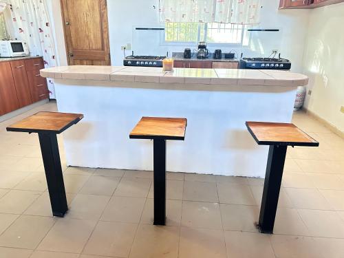 a kitchen with two wooden stools in front of a counter at Blasina el valle in Valle de Anton