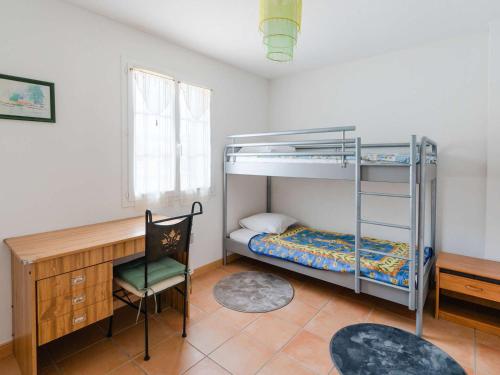 - une chambre avec des lits superposés, un bureau et une chaise dans l'établissement Villa 4 pièces pour 6 personnes avec terrasse, jardin, garage et WIFI à Narbonne-Plage - FR-1-409-136, à Narbonne-Plage