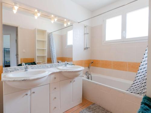 une salle de bain avec deux lavabos et une baignoire dans l'établissement Villa 4 pièces pour 6 personnes avec terrasse, jardin, garage et WIFI à Narbonne-Plage - FR-1-409-136, à Narbonne-Plage