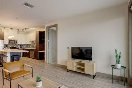 a living room with a television and a kitchen at Modern 2BR CozySuites on Town Lake waterfront 13 in Tempe