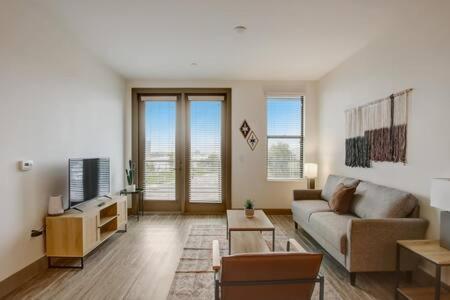 a living room with a couch and a tv at Modern 2BR CozySuites on Town Lake waterfront 13 in Tempe