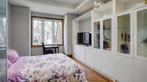 a bedroom with a bed and a flat screen tv at Toronto Modern House in Toronto