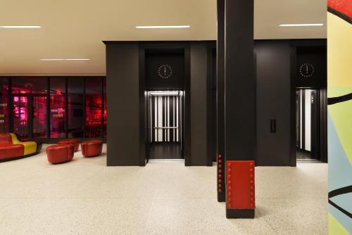 a lobby with red chairs and a black door at Pod 39 in New York